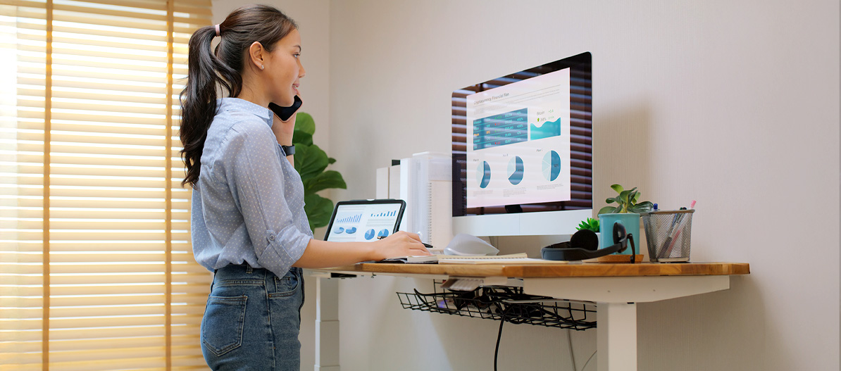 Person working on a computer, standing with an elevated desk